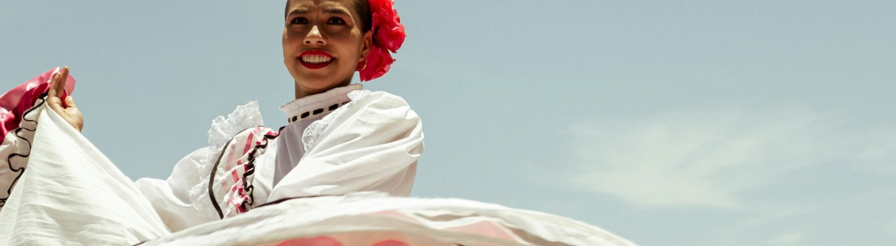 A woman in a white dress is riding a horse
